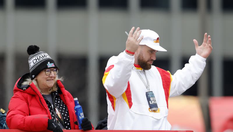Kansas City Chiefs tight end Travis Kelce, right, reacts as he rides in a victory parade with his mother, Donna Kelce, left, through downtown Kansas City, Mo., on Feb. 15, 2023, while celebrating his team’s NFL Super Bowl win with fans.