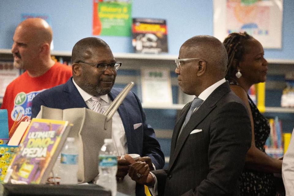 Antonio White, vicepresidente de United Teachers of Dade, el sindicato de maestros de Miami-Dade, a la izquierda, y Steve Gallon III, vicepresidente de la Junta Escolar de Miami-Dade, hablan antes de una conferencia de prensa para promover el referendo del 8 de noviembre, el jueves 6 de octubre de 2022, en Madie Ives K-8 Center, en Miami. El distrito está pidiendo a los electores que aumenten sus impuestos a la propiedad para financiar los aumentos de los salarios de maestros y agentes de recursos escolares.