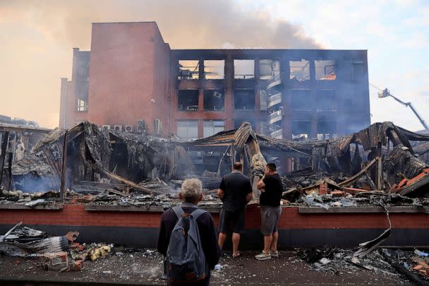 PHOTO: People look at a building burned during nighttime clashes between protesters and police in Roubaix, northern France, on June 30, 2023, three days after 17-year-old Nahel M. was shot dead by an officer in a Paris suburb. (Pascal Rossignol/Reuters)