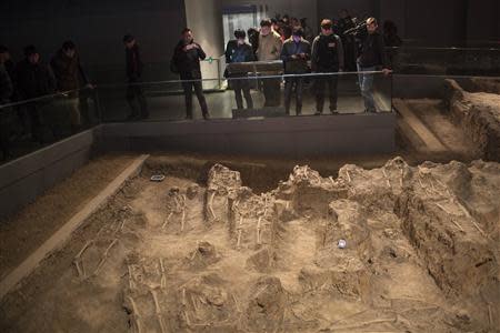 Journalists and visitors look at skeletons of victims of the 1937 Nanjing massacre at the Nanjing Massacre Museum during a media trip, in Nanjing, Jiangsu province, February 19, 2014. REUTERS/Aly Song