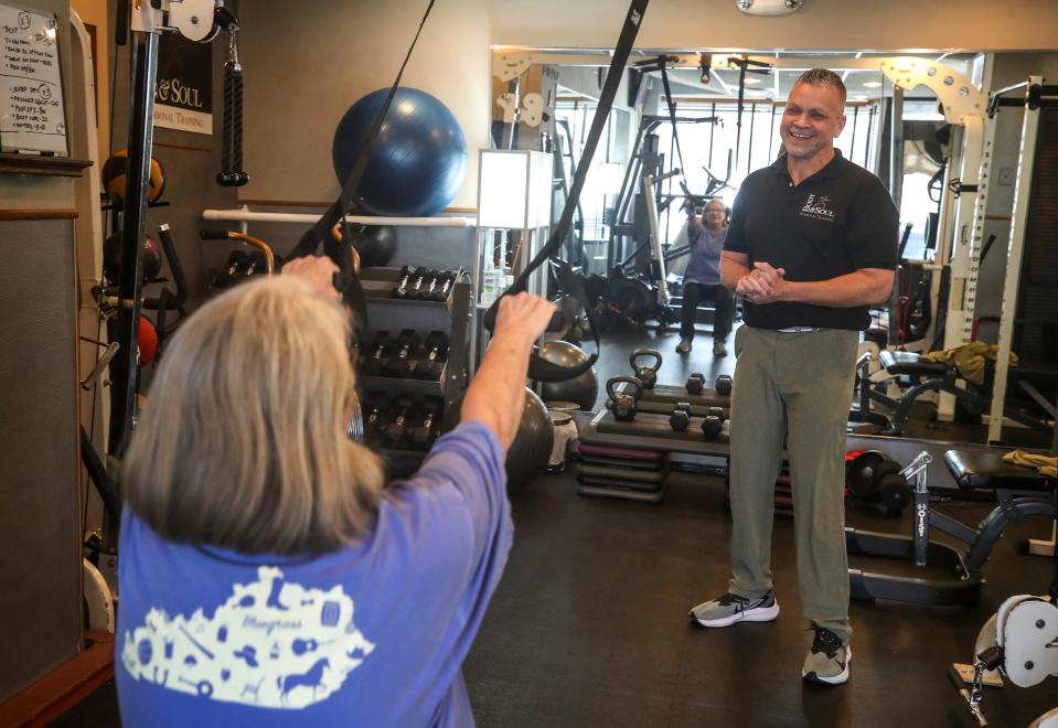 Bruce Miller, owner of Body & Soul, works with Barbara Davies during her workout.