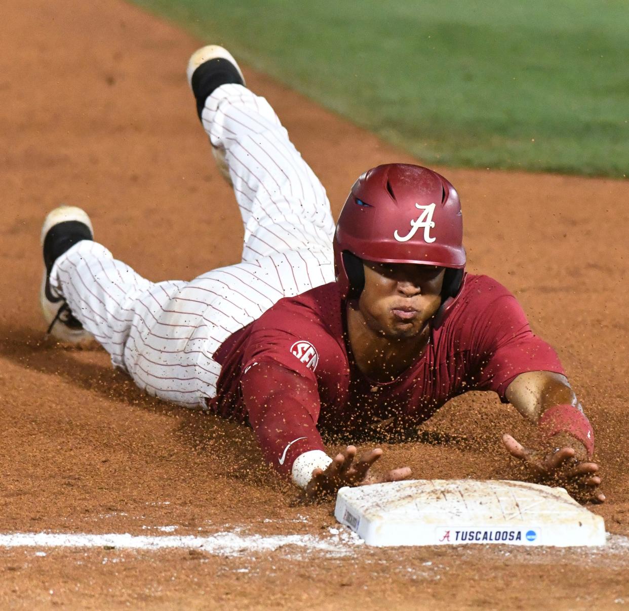 Alabama base runner Andrew Pinckney (21) slides safely into third on a sacrifice fly at Sewell-Thomas Stadium in Tuscaloosa, Ala., Saturday June 4, 2023. Alabama defeated Troy 11-8 in the winners bracket game of the NCAA Regional Baseball Tournament. 