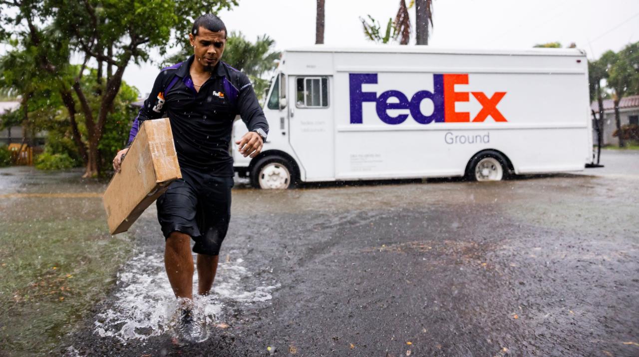 FedEx driver Rico Torres, 33, delivers a package to a home as heavy rain falls over parts of South Florida on Wednesday, June 12, 2024, in Hollywood, Fla. (Matias J. Ocner/Miami Herald via AP)