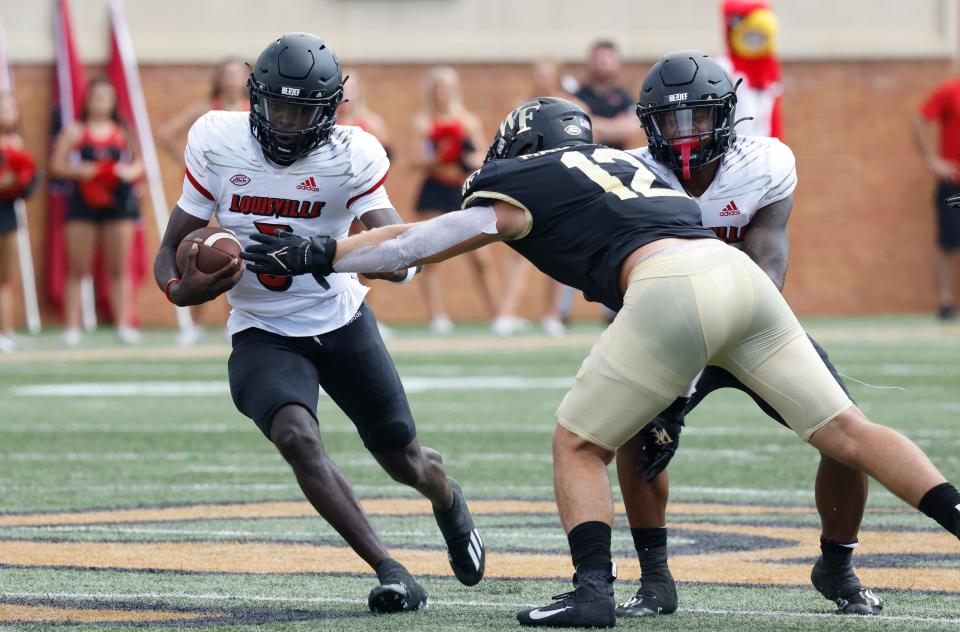 Oct 2, 2021; Winston-Salem, North Carolina, USA;  Louisville Cardinals quarterback Malik Cunningham (3) runs the ball as Wake Forest Demon Deacons defensive back Luke Masterson (12) is blocked by running back Trevion Cooley (23) during the second  quarter at Truist Field. Mandatory Credit: Reinhold Matay-USA TODAY Sports