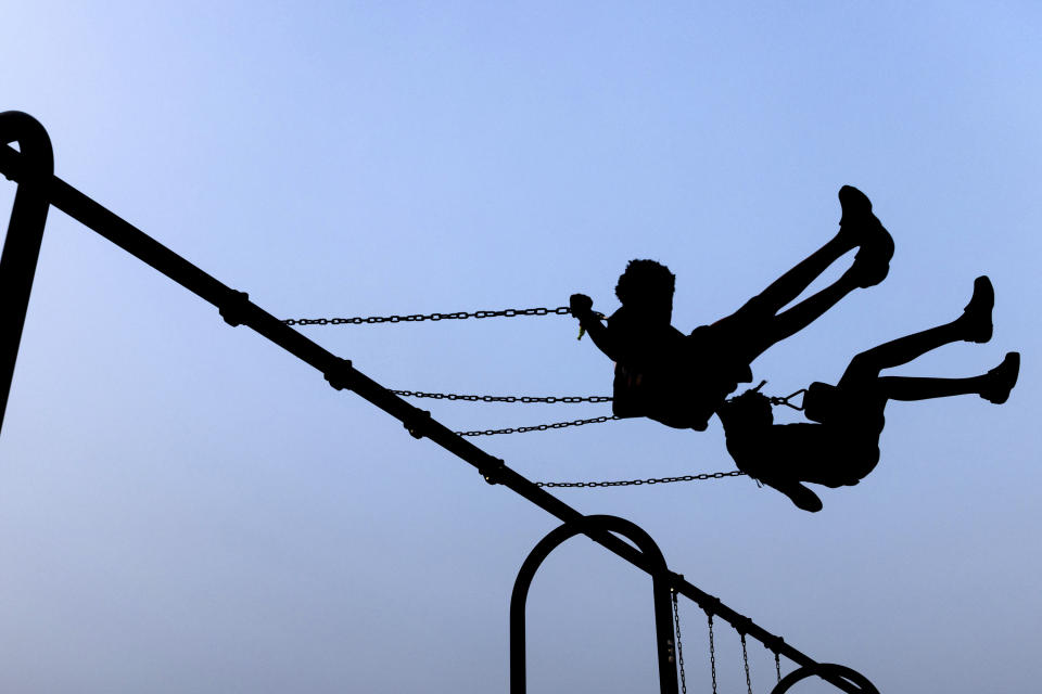 Children play on swings during National Night Out, Tuesday, August 1, 2023, in Salisbury, Md. The event, hosted by the Salisbury Police Department, aims to promote stronger community relationships and includes a number of organizations that provide support services to families. (AP Photo/Julia Nikhinson)