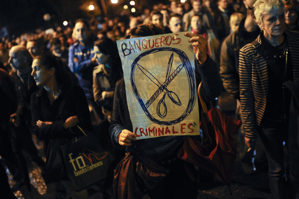 People hold a banner that reads: ''Bankers, Criminals'' during a protest march against eviction in Barakaldo, northern Spain, Friday, Nov. 9, 2012. Officials say a woman fell to her death as bailiffs approached to evict her for non-payment of the mortgage from her fourth-floor apartment in a suburb of the northern Spanish city of Bilbao. Amaia Egana, 53-year-old, who worked at a local bus depot, was married to a former town councilor and had a 21-year-old daughter, launched herself off her balcony Friday, the regional Interior Ministry said. (AP Photo/Alvaro Barrientos)