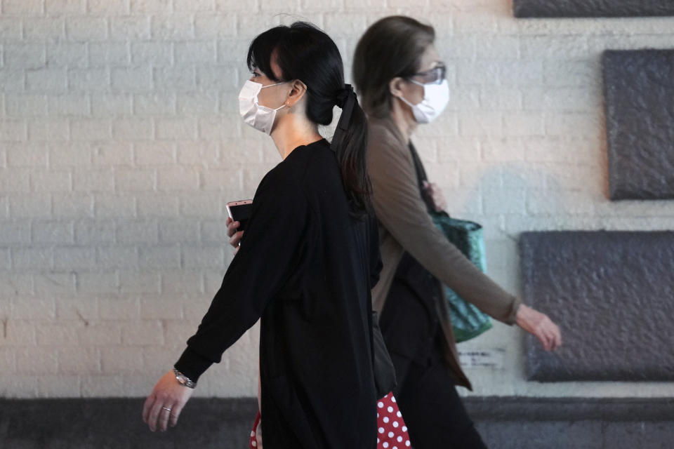 Women wearing protective masks to help curb the spread of the coronavirus walk Friday, Oct. 16, 2020, in Tokyo. The Japanese capital confirmed more than 180 new coronavirus cases on Friday. (AP Photo/Eugene Hoshiko)