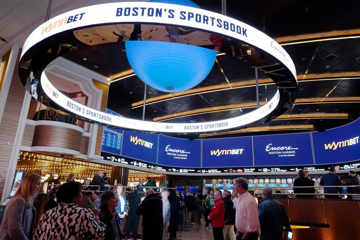 A sign, above, calls attention to sports betting at Encore Boston Harbor casino Tuesday in Everett. Massachusetts sports fans who want to wager on their favorite teams are finally getting their chance as the state kicks off sports betting at casinos in the state beginning Tuesday with online betting likely to follow in a few months.