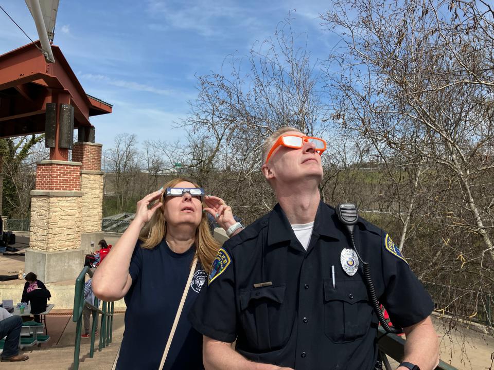 Jack Davis, retired Cuyahoga Falls police chief, takes a break from event duty to view the eclipse Monday with his wife, Katie Davis, at EclipseFest in Cuyahoga Falls.