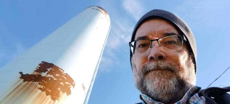 Addison has one of the few remaining standpipe water towers in the country. It is soon to be demolished when its modern replacement is constructed. Daily Telegram history columnist Dan Cherry is pictured with Addison's water tower.