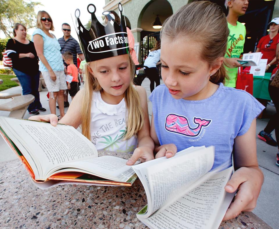 Children look over their new books during the World of Reading event at Barnett Family Park in Lakeland in 2018.This year's event is Saturday.