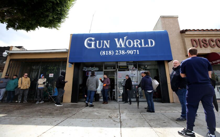 Customers line up outside Gun World on Magnolia Ave. in Burbank on Tuesday, March 17, 2020. Some were purchasing ammunition and others guns.