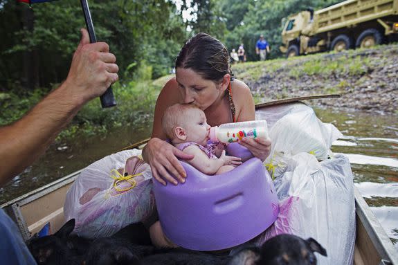 Danielle Blount kisses her 3-month-old baby Ember as she feeds her while they wait to be evacuated by members of the Louisiana Army National Guard near Walker, La.