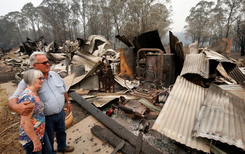 Lyn and Peter Iverson with their burnt out office and shed on their property at Half Chain road, Koorainghat