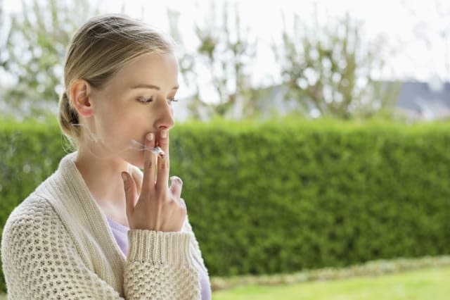 Woman smoking cigarette in park