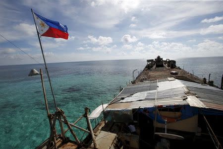 A Philippine flag flutters from BRP Sierra Madre, a dilapidated Philippine Navy ship that has been aground since 1999 and became a Philippine military detachment on the disputed Second Thomas Shoal, part of the Spratly Islands, in the South China Sea March 29, 2014. REUTERS/Erik De Castro