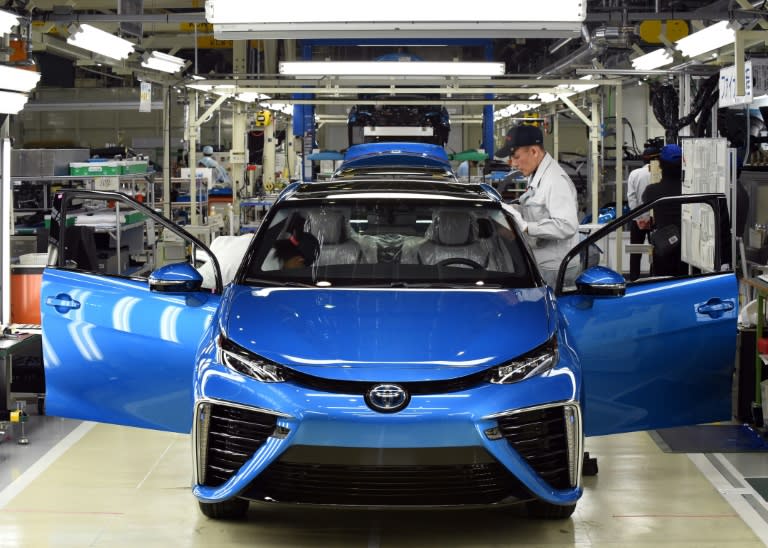 Employees of Toyota Motors check the FCV "Mirai" on its final assembly line during the vehicle's line off ceremony at the Motomachi factory in Toyota city, Aichi prefecture on February 24, 2015