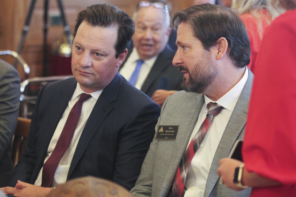 Korb Maxwell, left, an attorney for the Kansas City Chiefs, confers with former Kansas House Speaker Ron Ryckman Jr., right, R-Olathe, now a lobbyist for Scoop and Score, a nonprofit group pushing a plan to have Kansas issue bonds to finance a new stadium for the Chiefs, Monday, June 17, 2024, at the Statehouse in Topeka, Kan. (AP Photo/John Hanna)