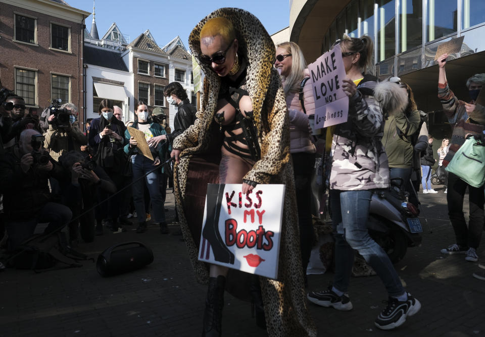 Sex workers carry signs protesting unequal treatment and stigmatizing during a demonstration in The Hague, Netherlands, Tuesday, March 2, 2021. Stores in one village opened briefly, cafe owners across the Netherlands were putting tables and chairs on their outdoor terraces and sex workers demonstrated outside parliament in protests against the government's tough coronavirus lockdown. (AP Photo/Patrick Post)