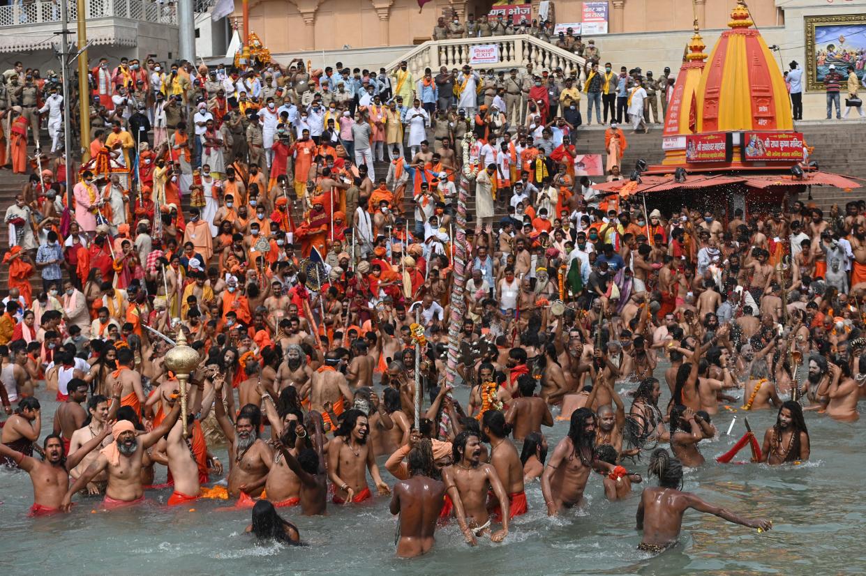 Naga Sadhus (Hindu holy men) take a holy dip in the waters of the Ganges River on the day of Shahi Snan (royal bath) during the ongoing religious Kumbh Mela festival, in Haridwar on April 12, 2021. (Photo by Money SHARMA / AFP) (Photo by MONEY SHARMA/AFP via Getty Images)