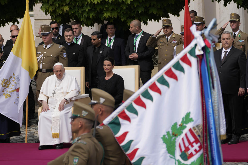 Pope Francis sits beside Hungary President Katalin Novák as he is welcomed by Hungarian authorities in the square of "Sándor" Palace in Budapest, Friday, April 28, 2023. The Pontiff is in Hungary for a three-day pastoral visit. (AP Photo/Darko Vojinovic)