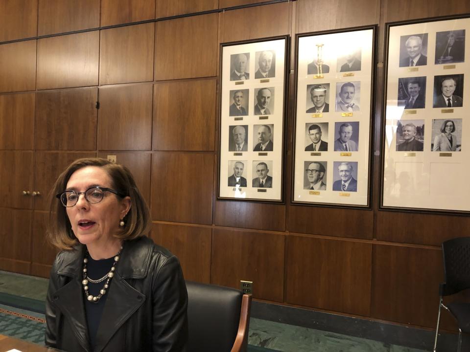 File - In this Feb. 7, 2019, file photo, Oregon Gov. Kate Brown speaks to reporters in front of pictures of previous state governors in Salem, Ore. Gov. Brown deployed the state police Thursday, June 20, 2019, to try to round up Republican lawmakers who fled the Capitol in an attempt to block a vote on a landmark climate plan. Minority Republicans want the cap and trade proposal aimed at dramatically lowering the state's greenhouse gas emissions by 2050 to be sent to the voters for approval instead of instituted by lawmakers. (AP Photo/Andrew Selsky, File)