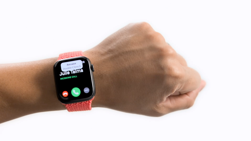 An Apple Watch user clenches their fist to demonstrate how to answer calls without touching the screen. It's part of the device's AssistiveTouch feature.