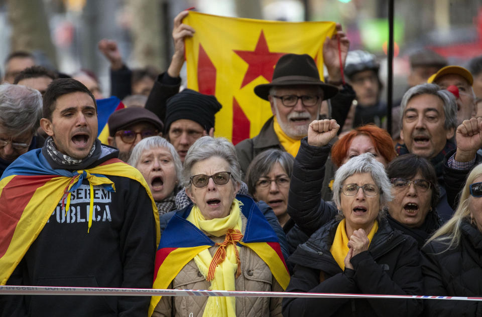 Supporter of Catalan regional president Quim Torra, gather outside Catalonia's high court in Barcelona, Spain, Monday, Nov.18, 2019. The pro-independence regional president of Catalonia is standing trial for allegedly disobeying Spain's electoral board by not removing pro-secession symbols from public buildings during an election campaign. Banner in Catalan reads "Freedom for political prisoners". (AP Photo/Emilio Morenatti)