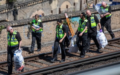 Police officers are seen carrying evidence bags on the train tracks near Loughborough Junction station  - Credit: Rob Pinney/LNP