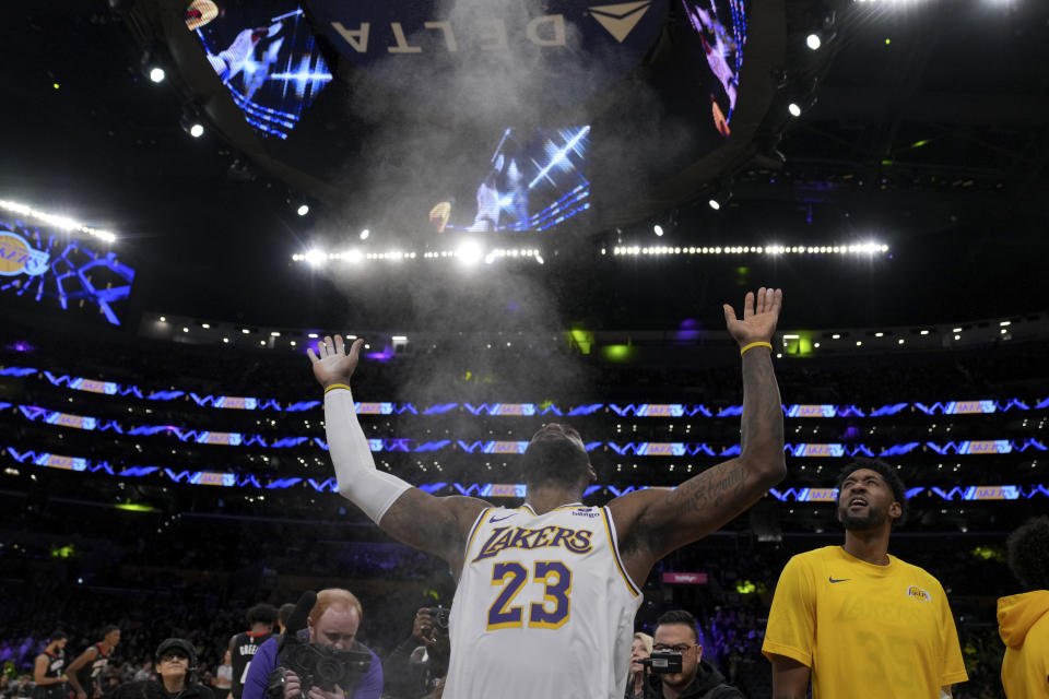 Los Angeles Lakers forward LeBron James (23) throws powder in the air before an NBA basketball game in Los Angeles, Sunday, Nov. 19, 2023. (AP Photo/Eric Thayer)