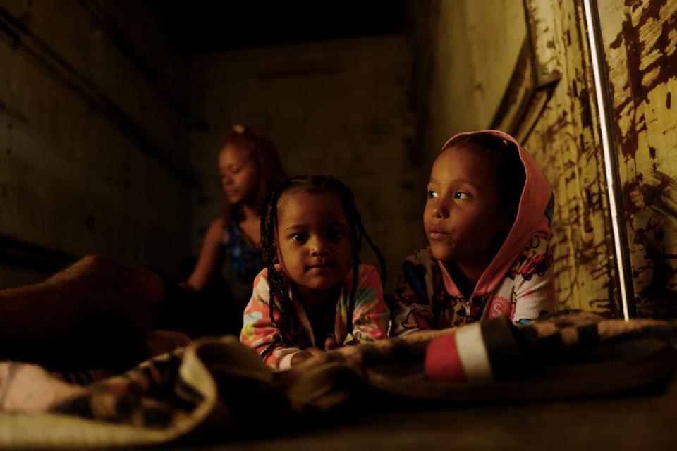 Seven-year-old Cathaleya, on the right, rests with another migrant girl inside a train carriage as she travels with her family (Reuters)