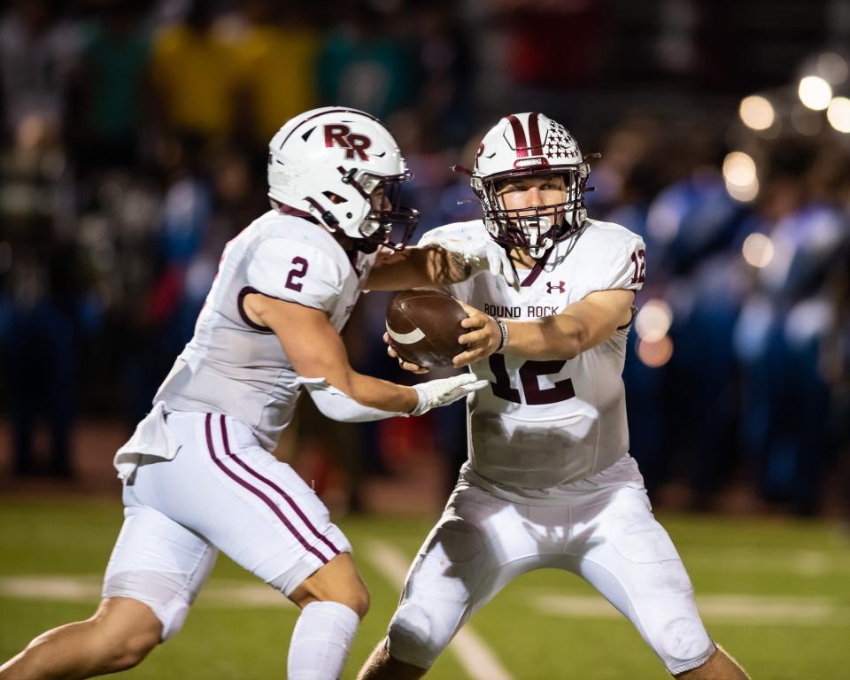 Round Rock quarterback Mason Cochran hands off to Vincent Mighetto-Frueh during the Dragons' win over Manor on Friday. Mighetto-Frueh rushed for  77 yards. Cochran ran for 68 yards and a touchdown and passed for another TD.