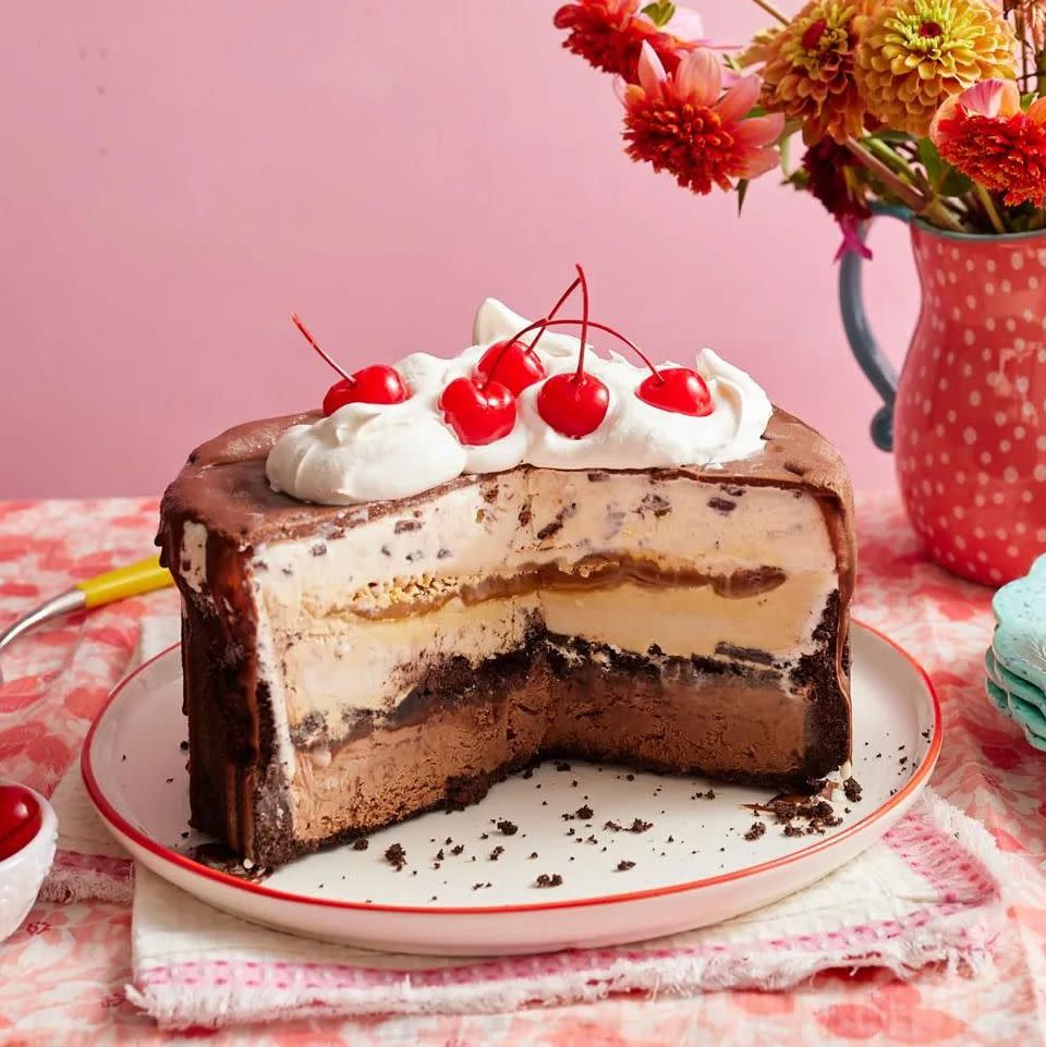ice cream cake with whipped cream and cherries on top