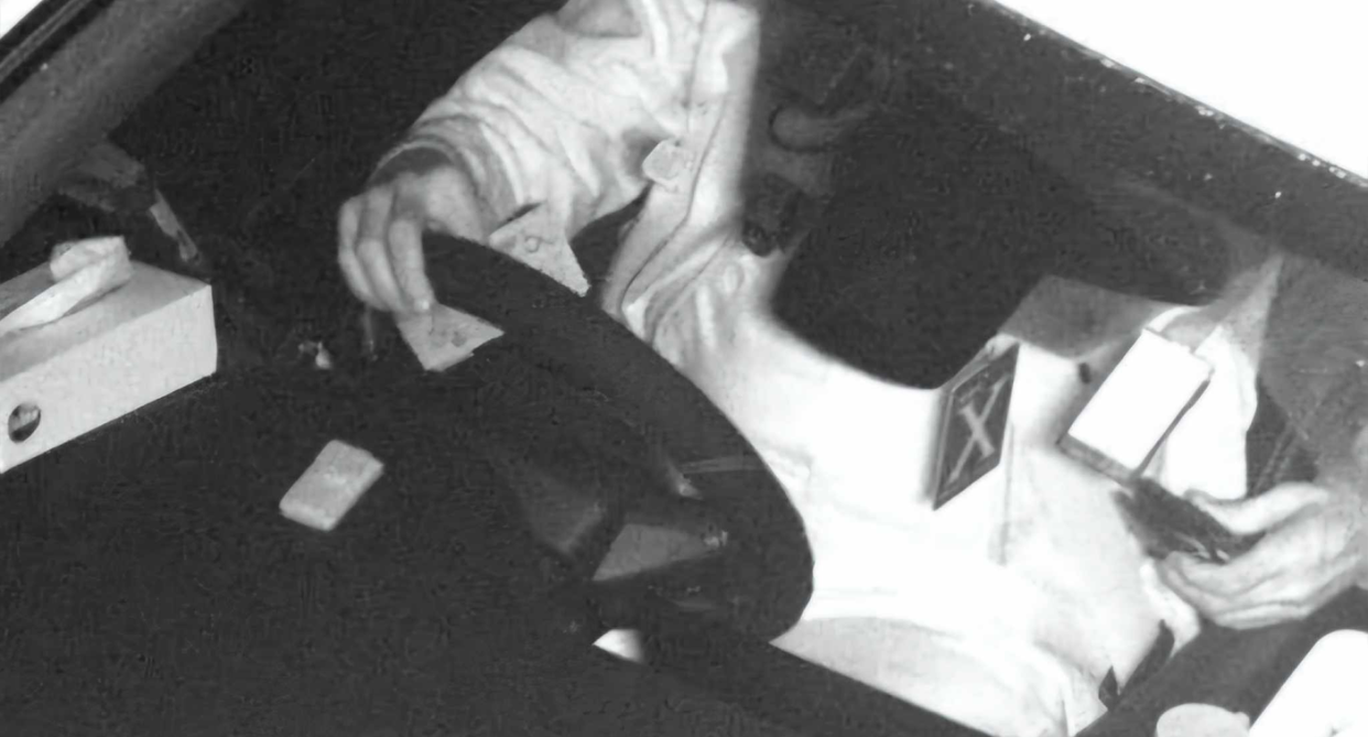 The image of the man driving shows he is holding something in each hand while holding the steering wheel. 