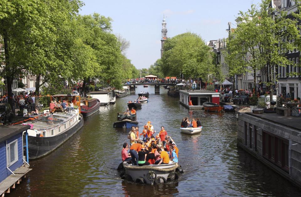 People celebrate King's Day at Prinsengracht in Amsterdam, Netherlands, Saturday, April 26, 2014. The Dutch celebrate the first ever King's Day, a national holiday held in honor of the newly installed monarch, King Willem Alexander. King's Day replaces the traditional Queen's Day. (AP Photo/Margriet Faber)