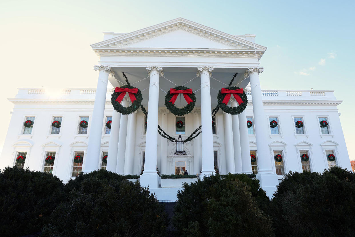 The White House with three large christmas wreaths hanging between the columns. (Kevin Dietsch / Getty Images)