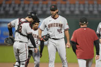 Arizona Diamondbacks starting pitcher Madison Bumgarner (40) stands on the mound and waits for a conference with pitching coach Matt Herges as catcher Carson Kelly and third baseman Eduardo Escobar (5) stand nearby during the fourth inning of the team's baseball game against the San Francisco Giants on Saturday, Sept. 5, 2020, in San Francisco. (AP Photo/Eric Risberg)