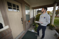 Vote canvasser Zach Martinez waits for a voter to answer the front door Tuesday, Nov. 1, 2022, in northeast Denver. Coloradans are taking the state's housing crisis into their own hands by turning to local and statewide ballot measures intgended to quell the soaring costs. (AP Photo/David Zalubowski)