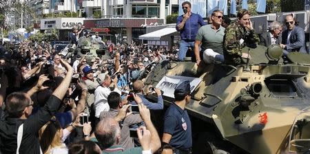 Cast members Sylvester Stallone (L), Dolph Lundgren (2ndL), Harrison Ford (2ndR) and Jason Statham pose on a tank as they arrive on the Croisette to promote the film "The Expendables 3" during the 67th Cannes Film Festival in Cannes May 18, 2014. REUTERS/Regis Duvignau