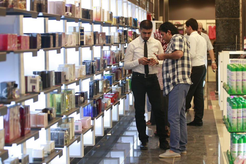 In this photo taken on Saturday, June 2, 2012, people shop at a department store in Baghdad's Azamiya neighborhood, Iraq. For residents of Azamiya, once one of Baghdad's most violent neighborhoods, the opening of a department store selling party dresses, imported men's suits and designer label perfumes is a hopeful sign that the worst may finally be behind them. (AP Photo/Hadi Mizban)