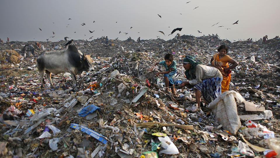 People searching for recyclable items at a landfill on the outskirts of New Delhi, India