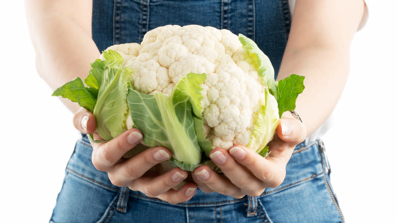 person holding cauliflower