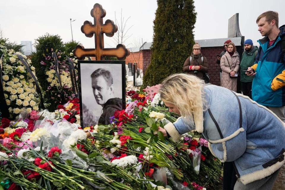 Woman lays flows at grave of Alexei Navalny (AP)