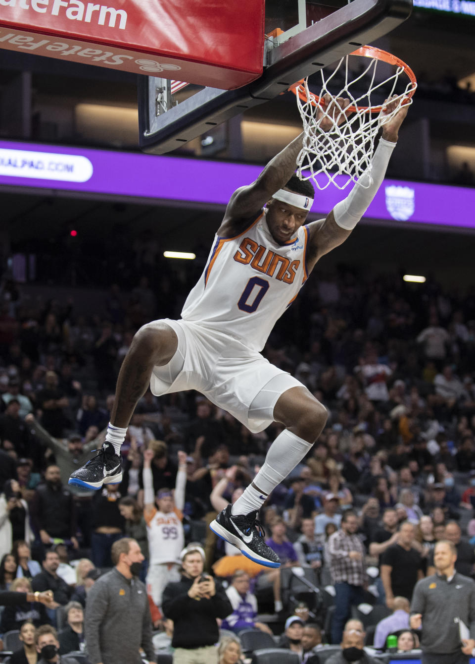 Phoenix Suns forward Torrey Craig (0) hangs off the rim after scoring off a dunk late in overtime of an NBA basketball game against the Sacramento Kings in Sacramento, Calif., Sunday, March 20, 2022. The Suns won 127-124.(AP Photo/José Luis Villegas)
