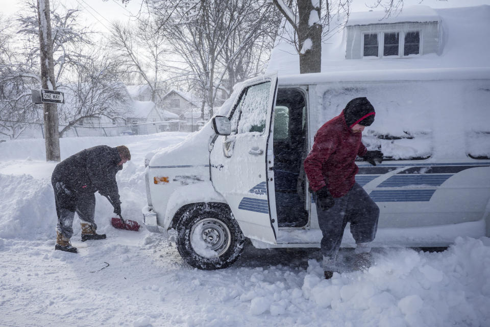 Karl Poulsen, left, helps Alex Shull get his van unstuck Sunday, Feb. 24, 2019, in Rochester, Minn., after heavy snow overnight. ( Joe Ahlquist/The Rochester Post-Bulletin via AP)