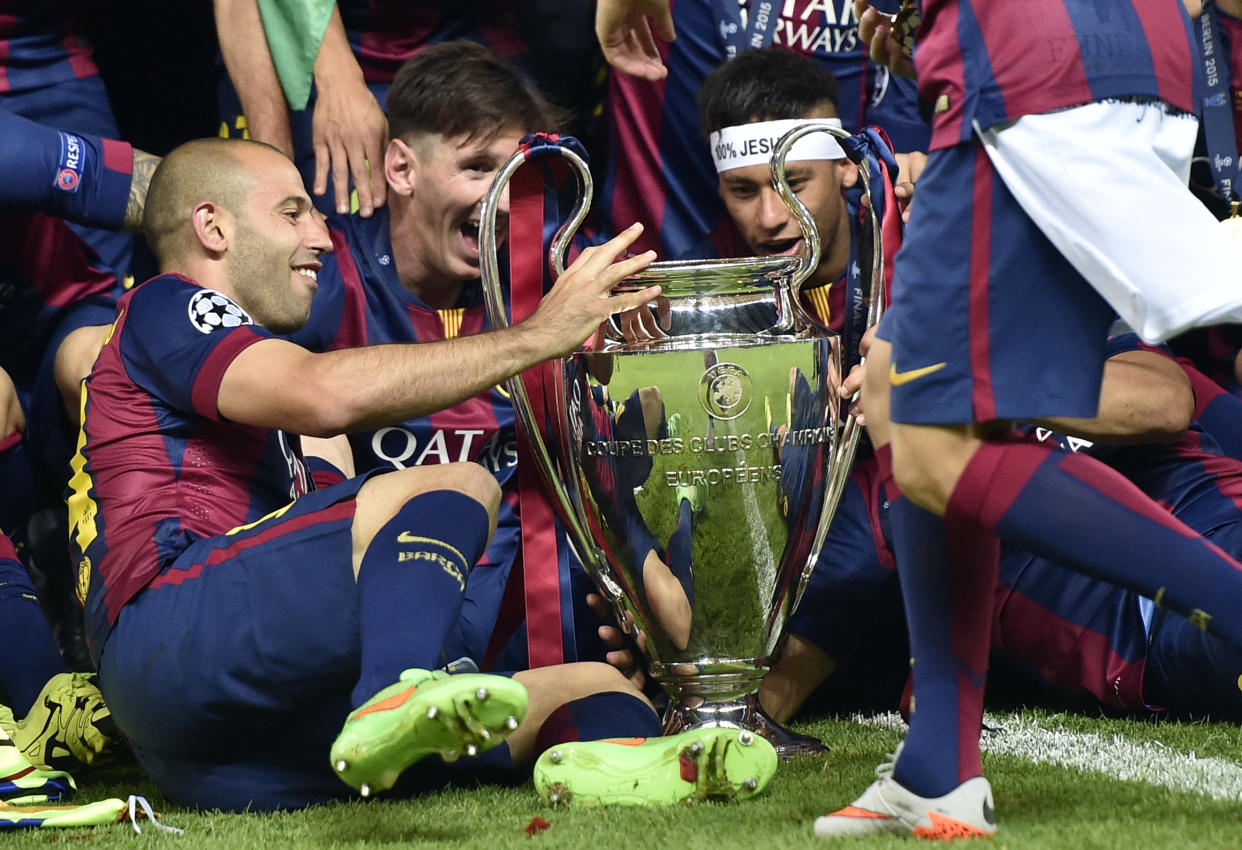 Barcelona&#39;s Javier Mascherano, Lionel Messi and Neymar, from left, celebrate with the trophy after winning 3-1 the Champions League final soccer match between Juventus Turin and FC Barcelona at the Olympic stadium in Berlin Saturday, June 6, 2015. (AP Photo/Martin Meissner)