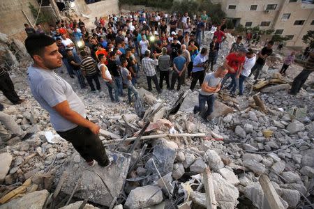 Palestinians stand next to the rubble of a house which was destroyed by Israeli troops during an Israeli raid in the West Bank city of Jenin September 1, 2015. REUTERS/Mohamad Torokman