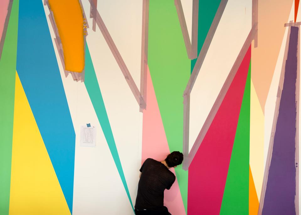 Alan Prazniak, assistant to Philadelphia artist Odili Donald Odita, help paints a mural on the wall in the new Stanley Museum of Art in Iowa City on Tuesday. The museum is set to open to the public Aug. 26.