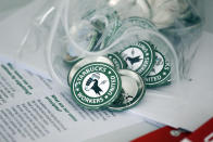 FILE — Pro-union pins sit on a table during a watch party for Starbucks' employees union election, Dec. 9, 2021, in Buffalo, N.Y. It’s become a common sight: jubilant Starbucks workers celebrating after successful votes to unionize at dozens of U.S. stores. But when the celebrations die down, a daunting hurdle remains. To win the changes they seek, like better pay and more reliable schedules, unionized stores must sit down with Starbucks and negotiate a contract. It’s a painstaking process that can take years. (AP Photo/Joshua Bessex, File)