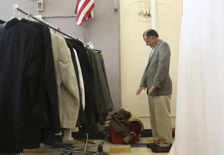 A military veteran checks the sizing of a suit jacket in San Francisco, California November 10, 2014. Homeless and low-income veterans received a complete suit and tips on how to look for job and housing interviews, a day before Veteran's Day. REUTERS/Robert Galbraith